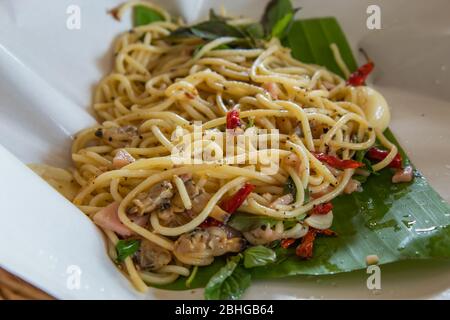 Die Spaghetti würzig gebratenen Muscheln auf den Bananenblättern. Stockfoto