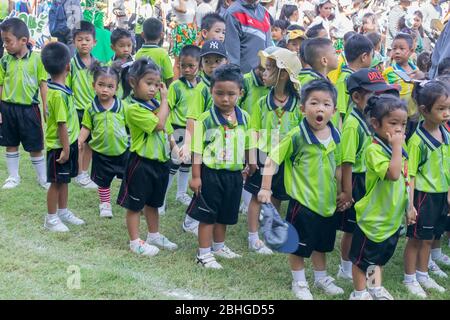 Thailändische Grundschüler in grünen Hemden stehen jeden Morgen in der Schlange zum marsch auf dem Schulfeld. Pranburi, Thailand 19. April 2018 Stockfoto