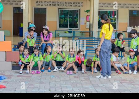 Die thailändischen Kindergartenschüler sitzen in der Wanthamaria-Schule, um sich mit ihren in der Nähe betreuten Lehrern zu unterhalten. Pranburi, Thailand April Stockfoto