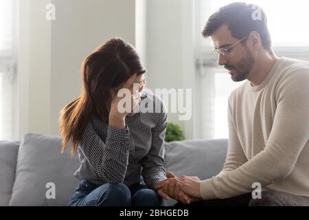 Schöner Mann tröstend Frau, Hände halten, zeigen Unterstützung. Stockfoto
