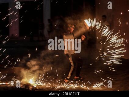 Ein palästinensischer Jugendlicher schwingt ein selbstgemachtes Feuerwerk, während er die erste Nacht des Heiligen Monats Ramadan im Lager Jabalia im nördlichen Gazastreifen feiert, von abgesagten iftar (Fast Breaking) Festen bis zu unterbrochenen Moschee-Gebeten, Muslime im gesamten Nahen Osten sind auf einen düsteren Monat des Fastens Ramadan vorbereitet, da die Bedrohung durch die COVID-19 Pandemie andauert. Der heilige Monat des Fastenmonats der Muslime Ramadan ist eine Zeit der Selbstreflexion und der Sozialisierung. Gläubige fasten von Sonnenaufgang bis Sonnenuntergang und versammeln sich dann um eine Familie oder Gemeinschaft für ein Essen jeden Abend des heiligsten Monats des Islam. Stockfoto