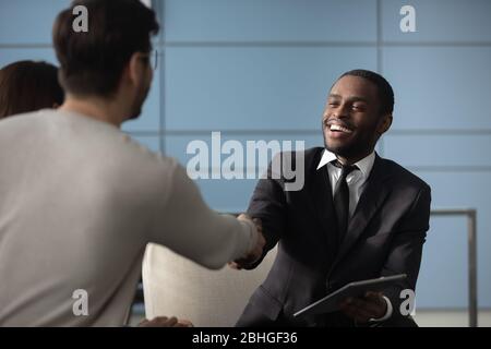 Gut aussehend afroamerikanischen Geschäftsmann im Anzug schütteln Hände mit Mann. Stockfoto