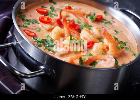 Nahaufnahme von Tom Yum Suppe, tom Kha Suppe in einem Topf auf einem Betontisch mit braunem Tuch Stockfoto