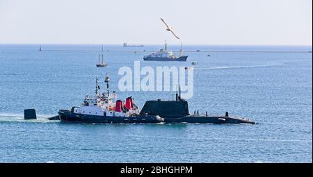 Nukleares U-Boot, das von zwei Schleppern in den Hafen eskortiert wird, Plymouth Sound, Devon, England, Großbritannien. Stockfoto