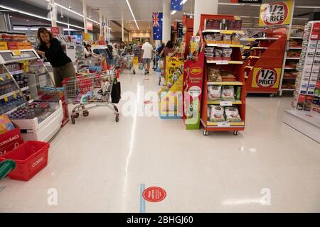 Coronavirus Bodenmarkierer in Coles Supermarkt beraten Kunden, wo sie stehen, um soziale Distanz Sydney Australien zu halten Stockfoto