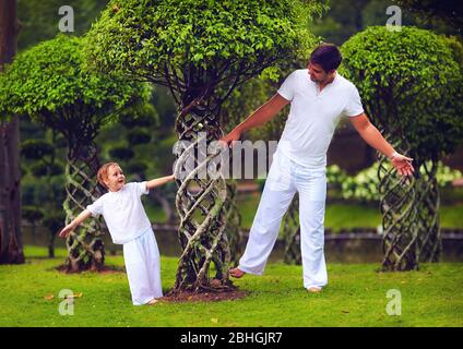 Vater und Sohn haben Spaß im orientalischen Bonsai Garten Stockfoto