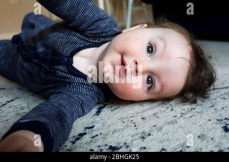 Schöner Junge, der während der Coronavirus Covid-19 Pandemie 2020 auf dem Boden spielt. Chichester, West Sussex, Großbritannien. Stockfoto