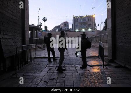 Jerusalem, Israel. April 2020. Israelische Grenzpolizisten tragen Gesichtsmaske wegen der COVID-19-Pandemie des Coronavirus, die einen palästinensischen Mann beim Betreten des Damaskus-Tores während des muslimischen Heiligen Monats Ramadan befragt.Altstadt Jerusalem Israel. Stockfoto