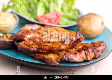 Gegrillte Schweinefleisch Steaks auf einem blauen Teller Stockfoto