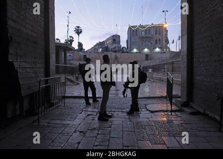 Jerusalem, Israel. April 2020. Israelische Grenzpolizisten tragen Gesichtsmaske wegen der COVID-19-Pandemie des Coronavirus, die einen palästinensischen Mann beim Betreten des Damaskus-Tores während des muslimischen Heiligen Monats Ramadan befragt.Altstadt Jerusalem Israel. Kredit: Eddie Gerald/Alamy Live News Stockfoto