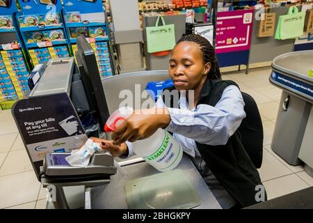 Kapstadt, Südafrika - 23. März 2020: Kassenpersonal an der Kasse wischt die Kreditkarte Maschine im Pick 'n Pay Supermarkt während des Virus Ausbruch Stockfoto