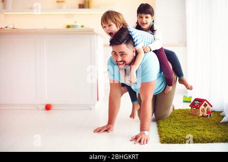 Glücklich verrückt Fahrt auf Vater's Rücken. Wenn Sie allein mit Kindern nach Hause Stockfoto