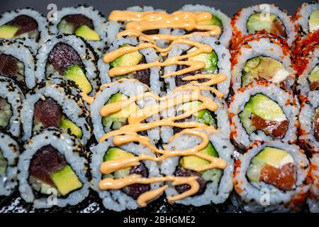 Eine abwechslungsreiche Auswahl an verschiedenen Arten von kalifornischen Sushi-Rollen auf einem Skateboard serviert Stockfoto
