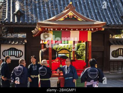 tokio, japan - märz 18 2020: Japanische Männer im happi Kimono diskutieren vor einem yatai-Wagen, in dem die Matsuri-Bayashi-Musikinstrumente stehen Stockfoto