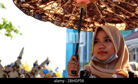 Pekalongan / Indonesien - 6. Oktober 2019: Wunderschöne Frauen tragen einzigartige Kostüme und tragen so ihre Teilnahme am Pekalongan Batik Karneval Stockfoto