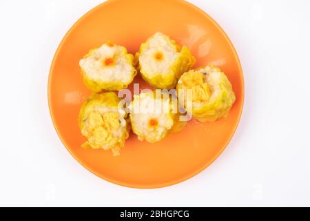 SIU Mai - Chinesische gedünstete Schweinefleischknödel auf Teller isoliert auf weißem Hintergrund. Stockfoto