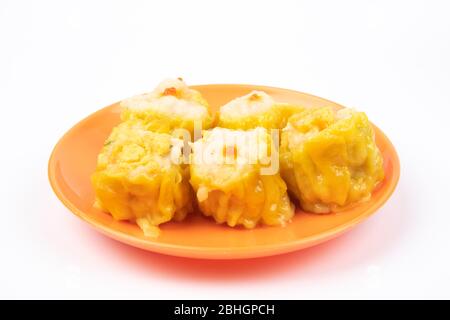 SIU Mai - Chinesische gedünstete Schweinefleischknödel auf Teller isoliert auf weißem Hintergrund. Stockfoto
