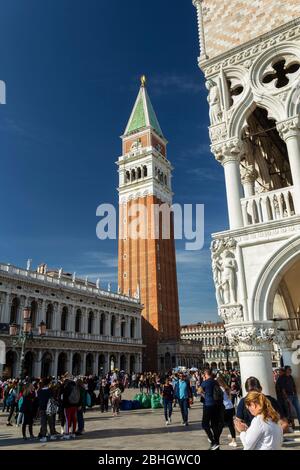Touristen in San Marco Piazza an einem sonnigen Oktobertag außerhalb Dogenpalast und dem Campanile. Stockfoto