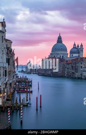 Der Grand Canal und die Basilica von Santa Maria della Salute von der Academia Brücke in Venedig bei Sonnenaufgang aus gesehen. Stockfoto