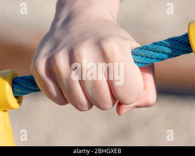 Halten Sie das Seil während des Kletterns an der Trainingswand mit der Hand. Detail des Seils mit Gelenkpunkt in Kunststoffabdeckung. Stockfoto