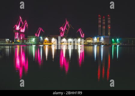 Lighting Giants - farbenfrohe beleuchtete Kräne bei Nacht in Pula, Istrien Halbinsel in Kroatien Stockfoto