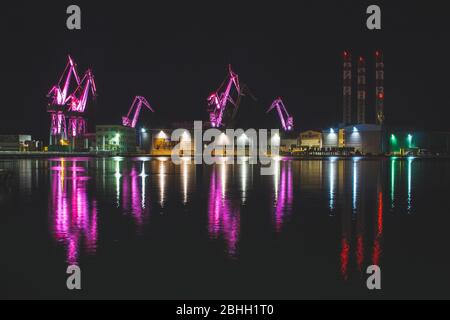 Lighting Giants - farbenfrohe beleuchtete Kräne bei Nacht in Pula, Istrien Halbinsel in Kroatien Stockfoto