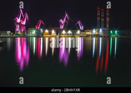 Lighting Giants - farbenfrohe beleuchtete Kräne bei Nacht in Pula, Istrien Halbinsel in Kroatien Stockfoto