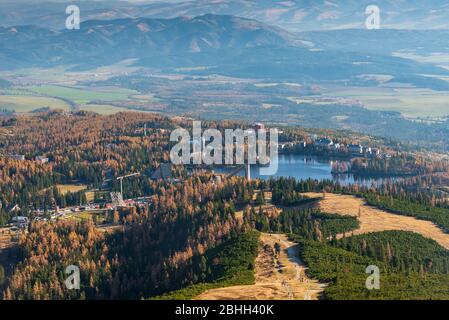 Strbske Pleso mit See, bunten Wald rund um und Kozie chrbty Gebirge im Hintergrund in Vysoke Tatry Berge in der Slowakei Stockfoto