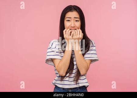 Probleme und Sorgen. Porträt von nervösen Mädchen mit langen Brünette Haare beißen Nägel und suchen erschrocken, Angst vor Problemen, leiden Phobie Stockfoto