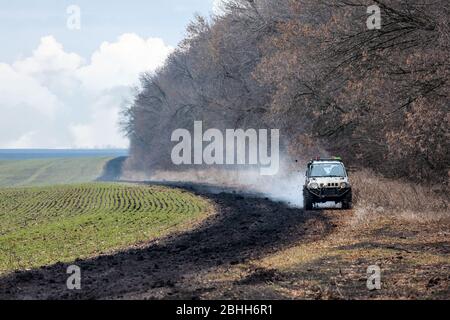 Das Geländewagen fährt auf einer schlechten, schmutzigen Straße. Stockfoto