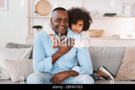 Verbundenheit zwischen Großeltern und Enkeln. Nettes Mädchen mit ihrem liebevollen Opa zu Hause Stockfoto