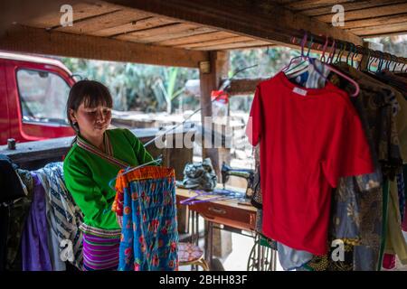 (200426) -- MENGHAI, 26. April 2020 (Xinhua) -- EIN Dorfbewohner trocknet Kleidung im Dorf Manbansandui im Dorf Mannan im Landkreis Menghai, südwestlich der Provinz Yunnan, 12. April 2020. Weit entfernt in den Bergen des südwestlichen Chinas Yunnan liegt der ehemalige Ort des von Armut geplagten Manbansandui Weilers, wo 17 Haushalte der ethnischen Gruppe Lahu lebten. Im Hinblick auf die Lebensgewohnheiten und Bräuche der Dorfbewohner wurde das Dorf 2009 in ein neues Gebiet an seinen ursprünglichen Standort verlegt, um das Lebensumfeld der Dorfbewohner zu verbessern und die Armut abzuschütteln. Zusätzlich zu den infras Stockfoto