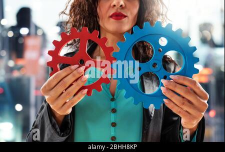 Geschäftsfrau versucht, mit Zahnrädern zu arbeiten. Konzept von Teamwork und Partnerschaft. Stockfoto