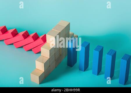 Konzept der covid19 Coronavirus Pandemie mit fallenden Kette wie ein Domino-Spiel. Ansteckung und Infektionsverlauf durch eine Mauer aus Backstein gestoppt. Zyan Stockfoto