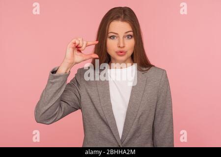 Braucht noch mehr! Porträt der skeptischen unzufrieden junge Frau im Business-Anzug machen ein wenig Geste, kleine Größe, unzufrieden mit niedriger Bewertung. ind Stockfoto