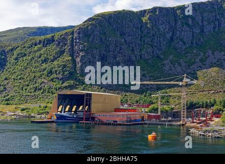 Die Baatbygg Werft in Maloy, mit einem Trawler in seinem überdachten Dock und einem Seismic Workboat im Vordergrund. Stockfoto