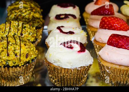 Mattierte Cupcakes stehen zum Verkauf. Abwechslungsreiche Aromen und bunte Dessert-Arten, ideal für Geburtstage, Party, Event, Catering, Bäckerei Konzept Stockfoto