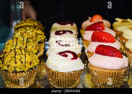 Mattierte Cupcakes stehen zum Verkauf. Abwechslungsreiche Aromen und bunte Dessert-Arten, ideal für Geburtstage, Party, Event, Catering, Bäckerei Konzept Stockfoto