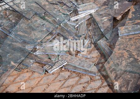 Große und kleine Scherben aus Glas auf einem Betonfeld. Zerbrochenes Glas Stockfoto