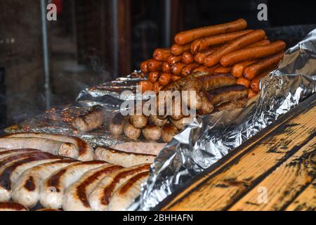 BBQ deutsche Würstchen werden von einem Verkäufer in Borough Market, London, Großbritannien gegrillt Stockfoto