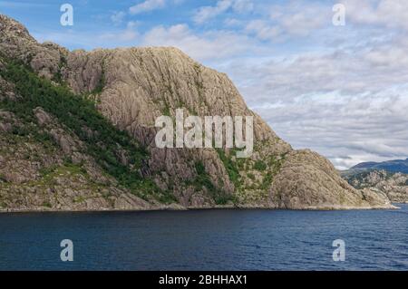 Eine sanft erodierte Felswand, die am Geirangerfjord bei Bergen an der Westküste Norwegens an einem Summers Day im August gesehen wurde. Stockfoto