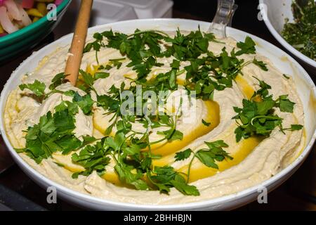 Hummus ist ein Dip, ein Aufstrich oder ein herzhaftes Gericht aus gekochten, pürierten Kichererbsen, die mit Tahini, Zitronensaft und Knoblauch gemischt werden. Es ist beliebt in der mittleren E Stockfoto