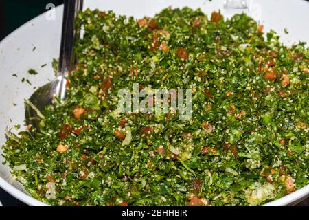 Tabbouleh ist ein levantiner vegetarischer Salat, der hauptsächlich aus fein gehackter Petersilie, mit Tomaten, Minze, Zwiebeln, Bulgur und gewürzt mit Olivenöl, lemo, hergestellt wird Stockfoto