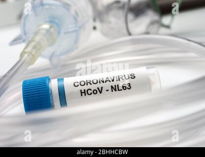 Fläschchen mit SARS-Cov-2 Coronavirus-Probe neben einer Sauerstoffmaske in einem Krankenhaus, konzeptionelles Bild Stockfoto