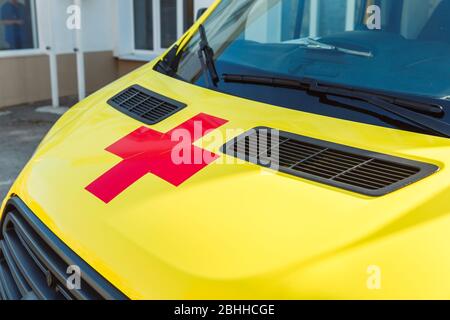 Das rote Kreuz auf der gelben Haube des Krankenwagens.Medizin und Gesundheitskonzept. Stockfoto