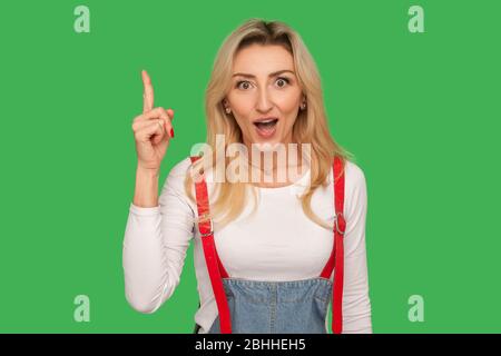 Eureka! Portrait der inspirierten fragte Erwachsene Frau in stilvollen Denim Overalls Zeigen Finger nach oben, überrascht von kreativen Idee, Genie intelligente Lösung. ind Stockfoto