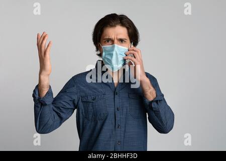 Sorge Mann Trägt Schutzmaske Und Emotional Sprechen Auf Handy Stockfoto