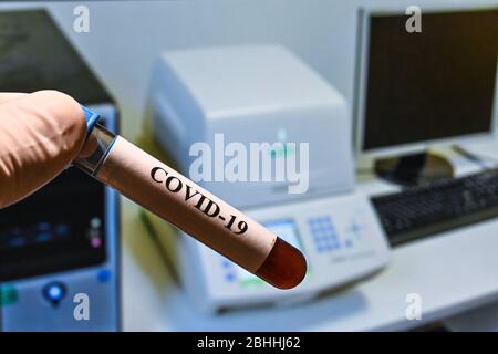 Real-Time PCR-Tests mit COVID-19. Ein Reagenzglas mit einer Probe auf dem Hintergrund des Verstärkungsgeräts. Stockfoto