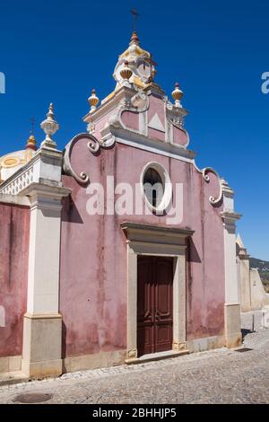 Helle farbe der Wände in bordeaux, weiße Details. Palast Estoi im Stil des Neo-Rokoko erbaut. Blick auf den Turm. Strahlend blauer Himmel. Estoi, Portugal. Stockfoto