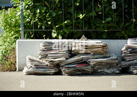 Mülltrennung in der Schweiz. Altes Papier in Paketen gebündelt und auf die Straße gestellt, um gesammelt zu werden. Stockfoto